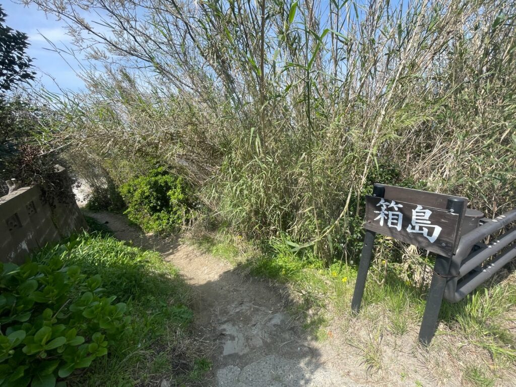 A sign on a path in the woods.