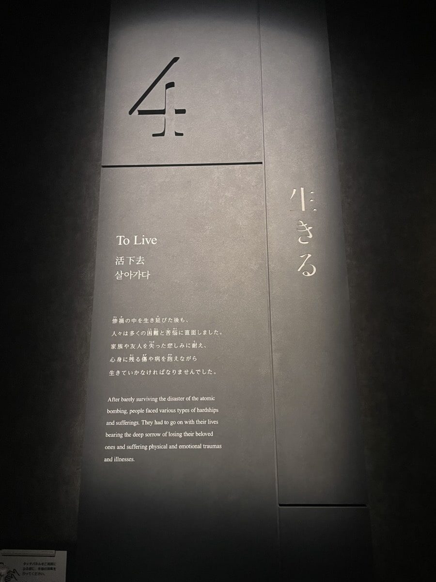 A museum panel titled "To Live" describes the hardships and suffering faced by atomic bombing survivors, in Japanese, Korean, and English text.